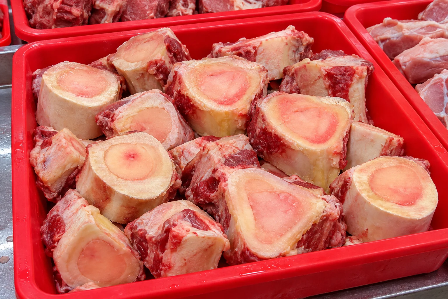 AI illustration of cross-cut beef marrow bones in a red wet-market stall tray