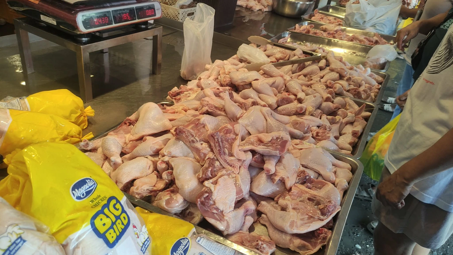 Fresh chicken pieces displayed at a market poultry stall